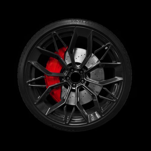 Car alloy wheel and tyre isolated on black background. New alloy wheel with tire and yellow carbon ceramic brakes. Alloy rim isolated. Car wheel disc. Car spare parts..